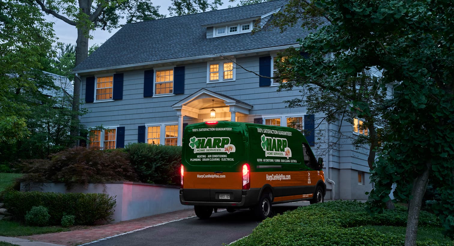 A Harp service van parked in a residential driveway at night, arriving to provide 24/7 emergency heating repair services.