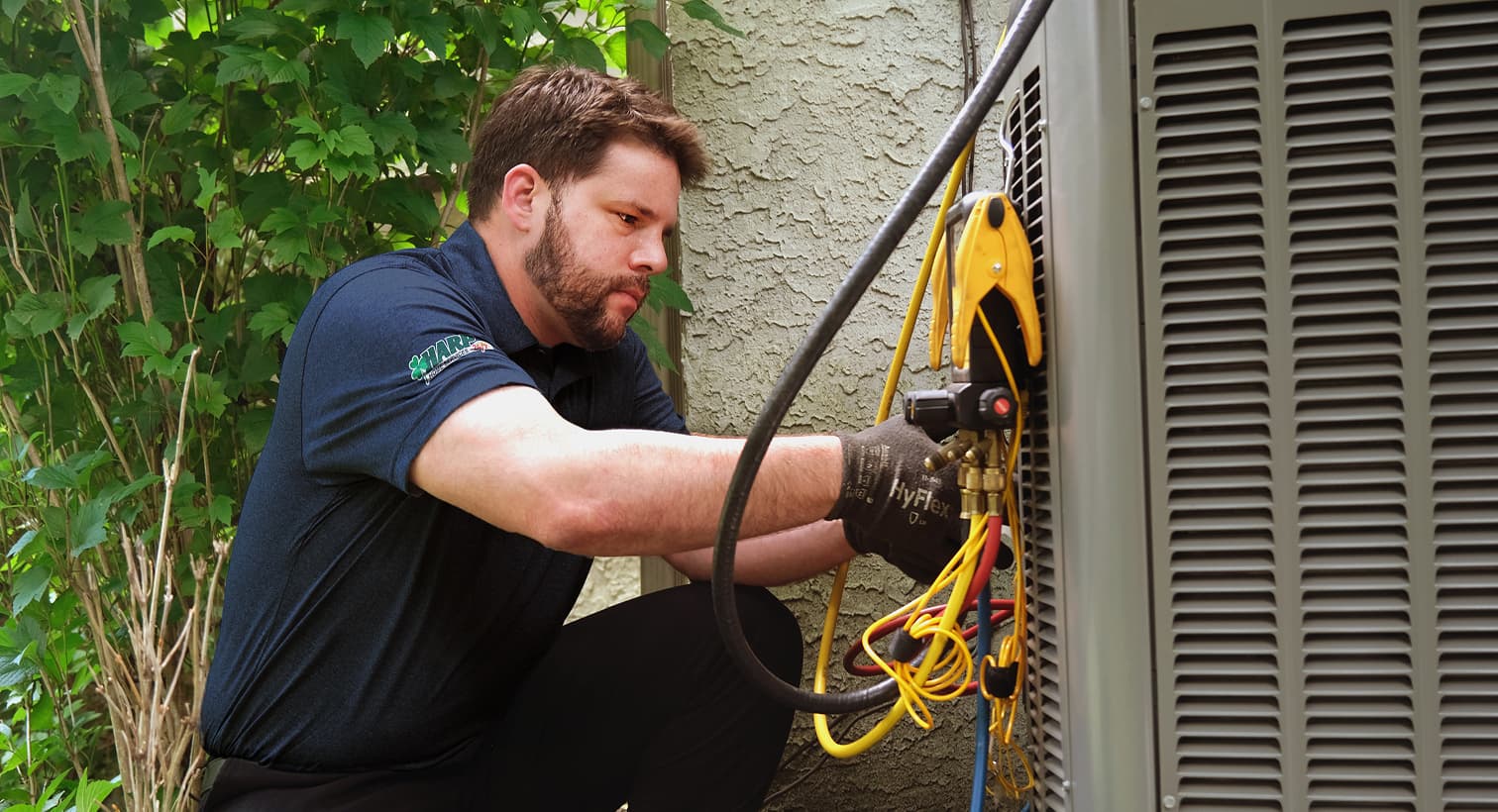 A professional Harp HVAC technician inspecting an outdoor central air conditioning unit to provide residential AC repair and diagnostic services.