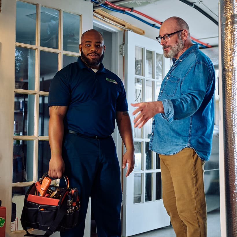 A Harp technician discusses the repair and installation services with a homeowner.