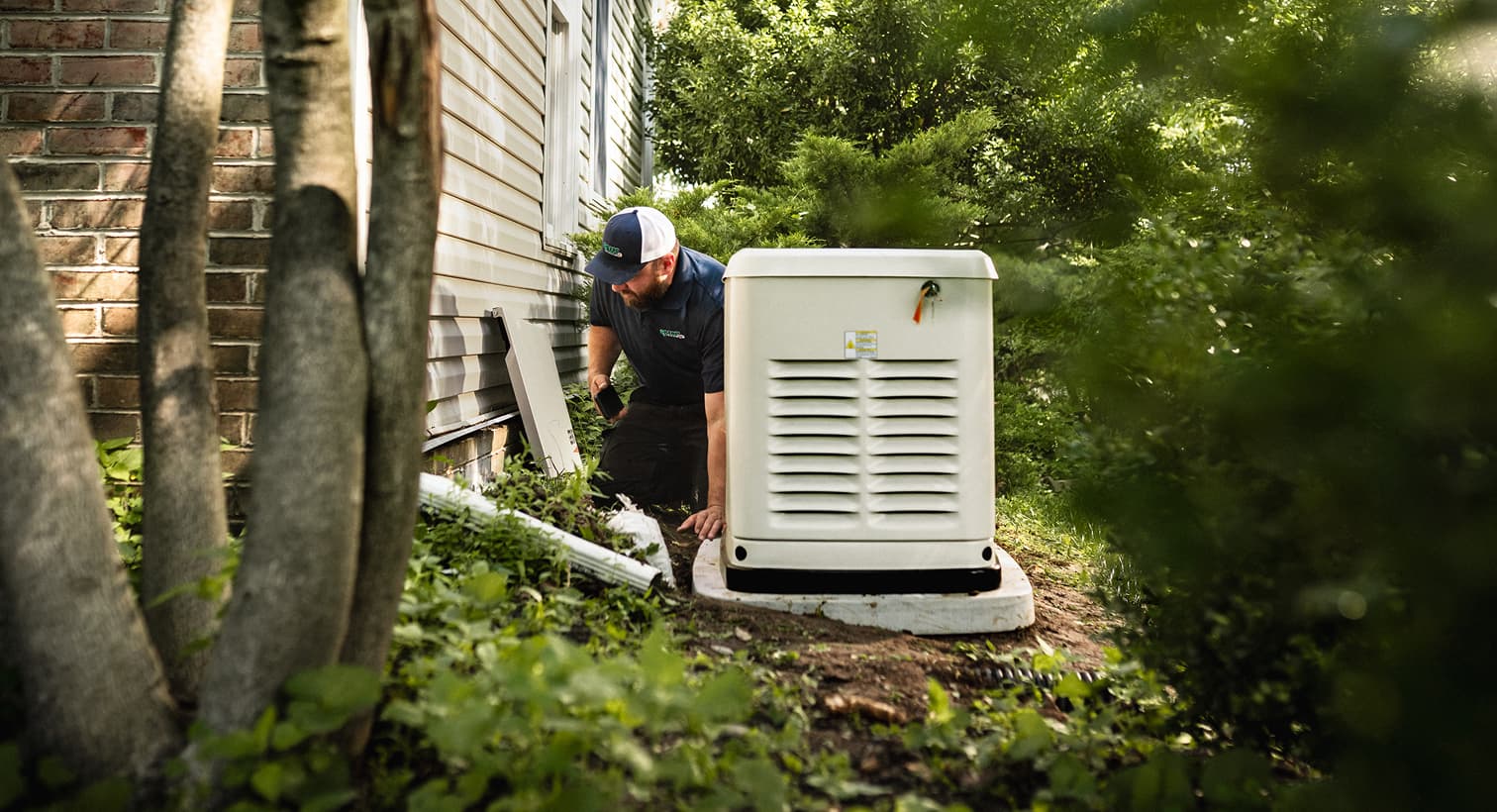 A professional Harp technician inspects a large, beige whole-home standby generator installed on a concrete pad outside a residential house.