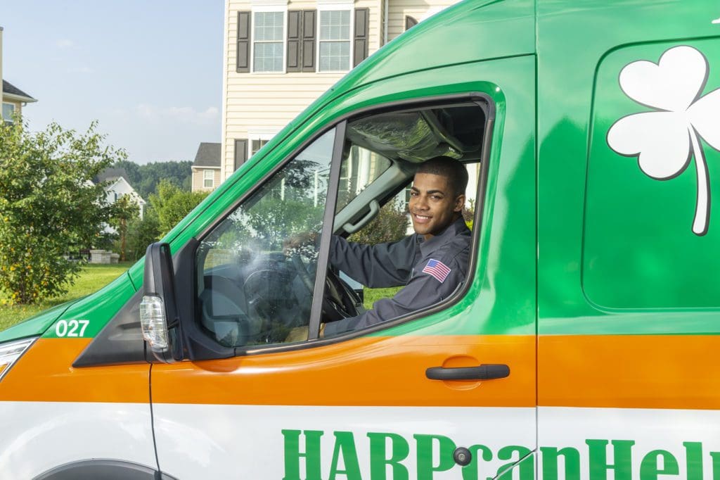 HARP Home Services technician smiling from the repair vehicle