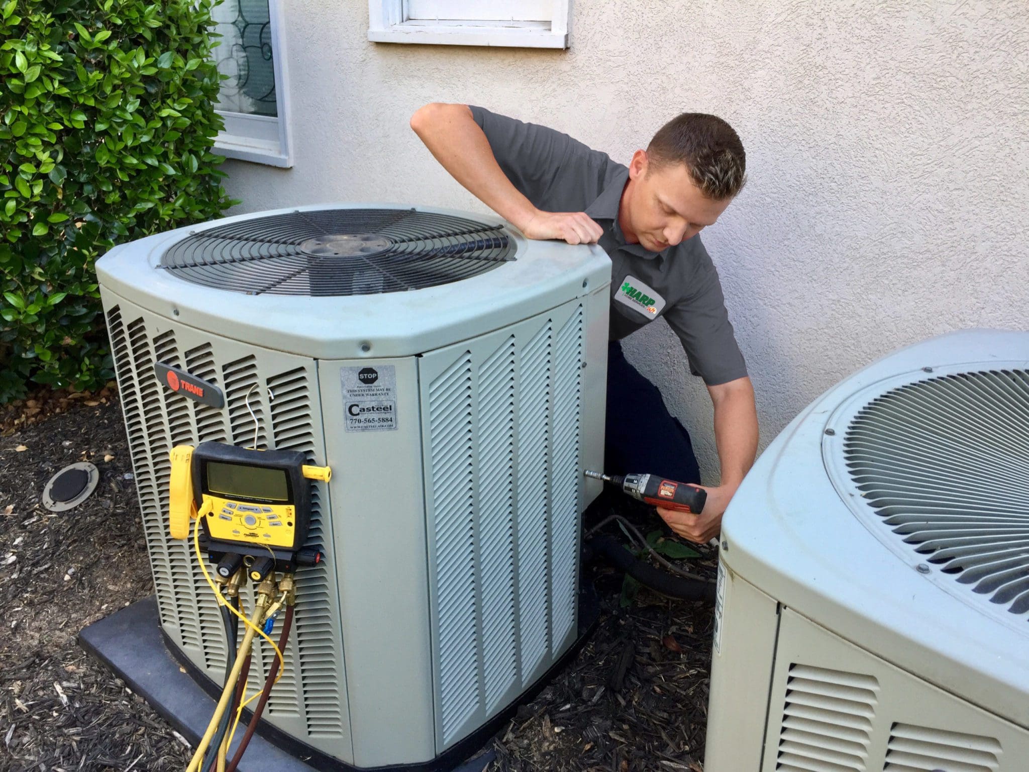 A HARP Home Services technician providing ac tune up services to a Connecticut homeowner