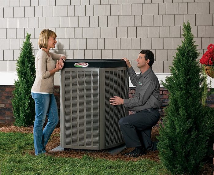 A HARP Home Services technician showing the new Lennox hvac unit installed to the house owner